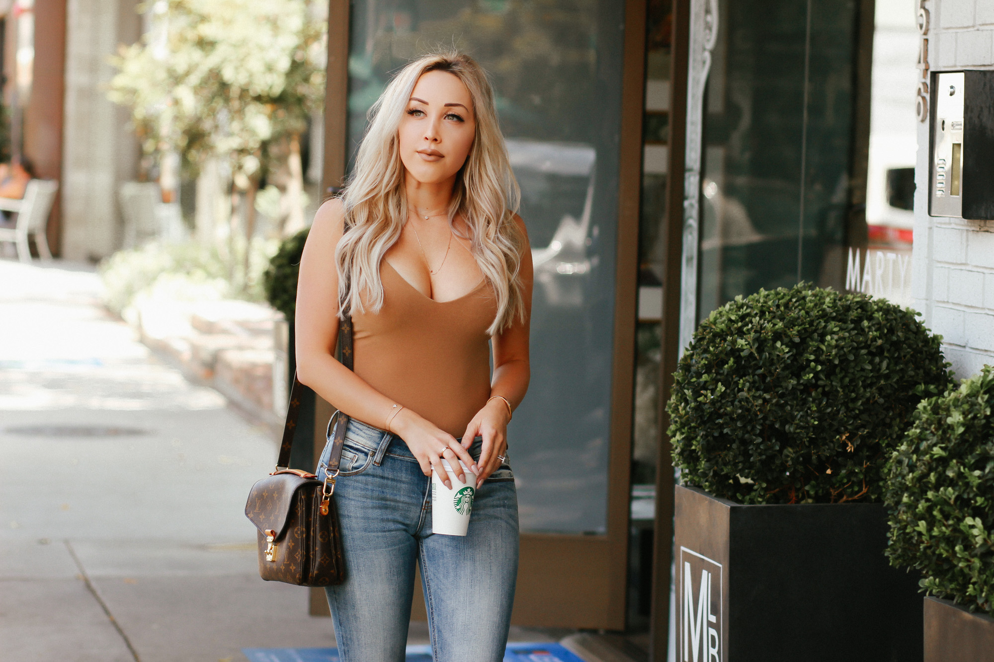 Nude Bodysuit, Blue ripped jeans | Louis Vuitton Pochette Metis | Blondie in the City by Hayley Larue