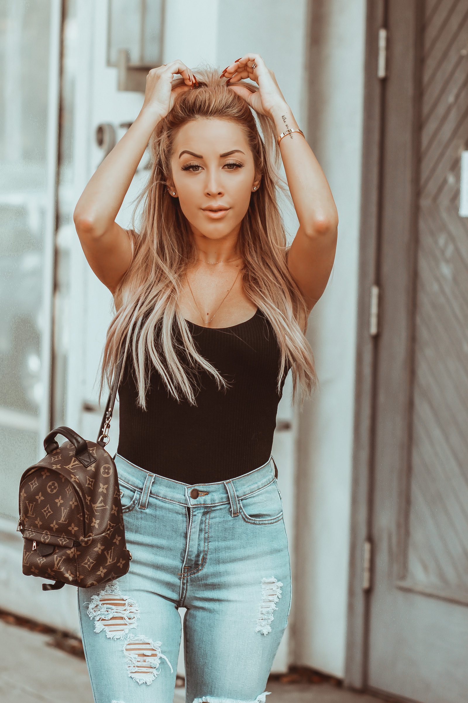Black Bodysuit Revolve | Distressed Jeans | Louis Vuitton Palm Springs Backpack | Hair Half Up Half Down | Gucci Mules | Blondie in the City by Hayley Larue