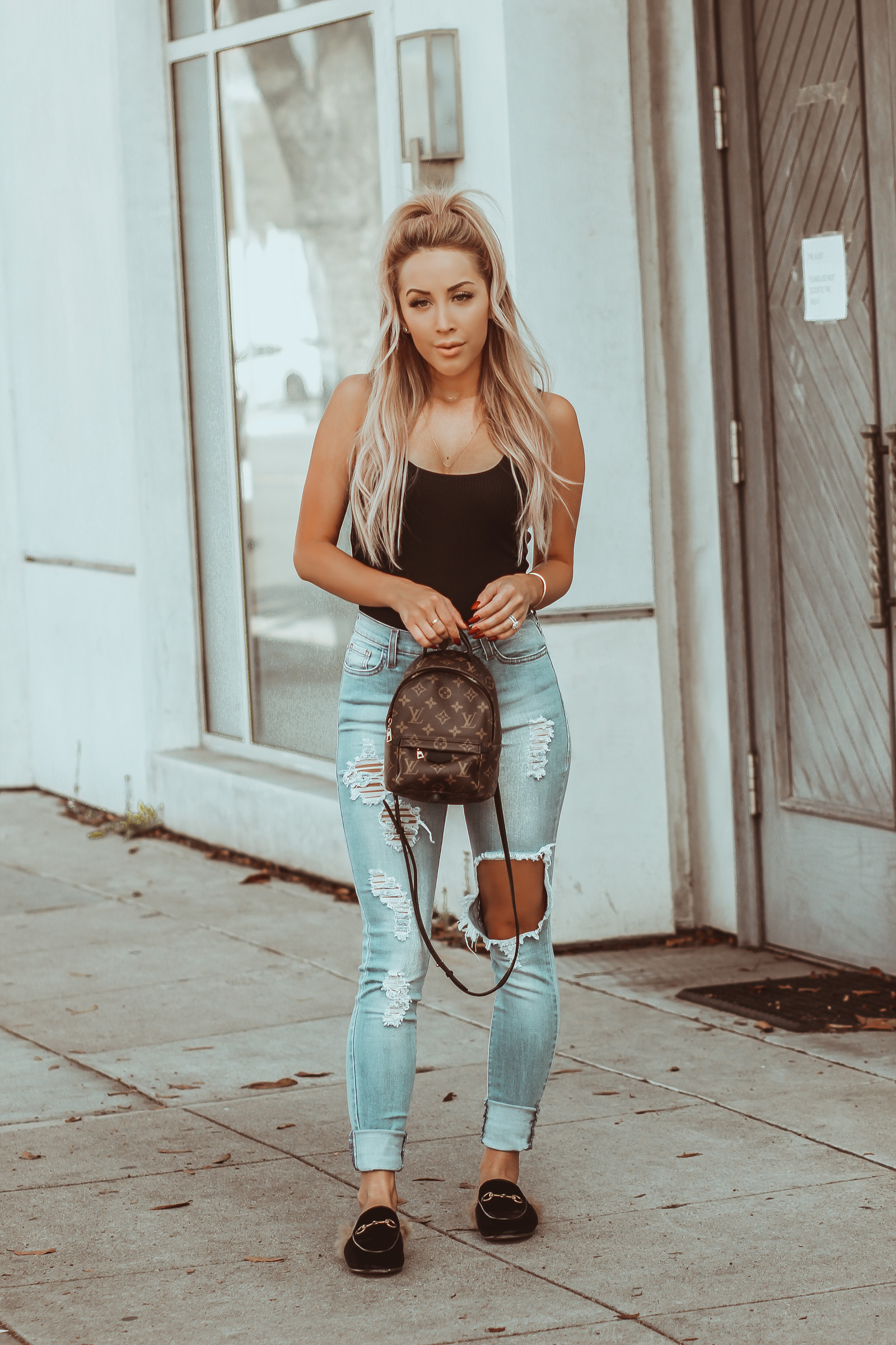 Black Bodysuit Revolve | Distressed Jeans | Louis Vuitton Palm Springs Backpack | Hair Half Up Half Down | Gucci Mules | Blondie in the City by Hayley Larue
